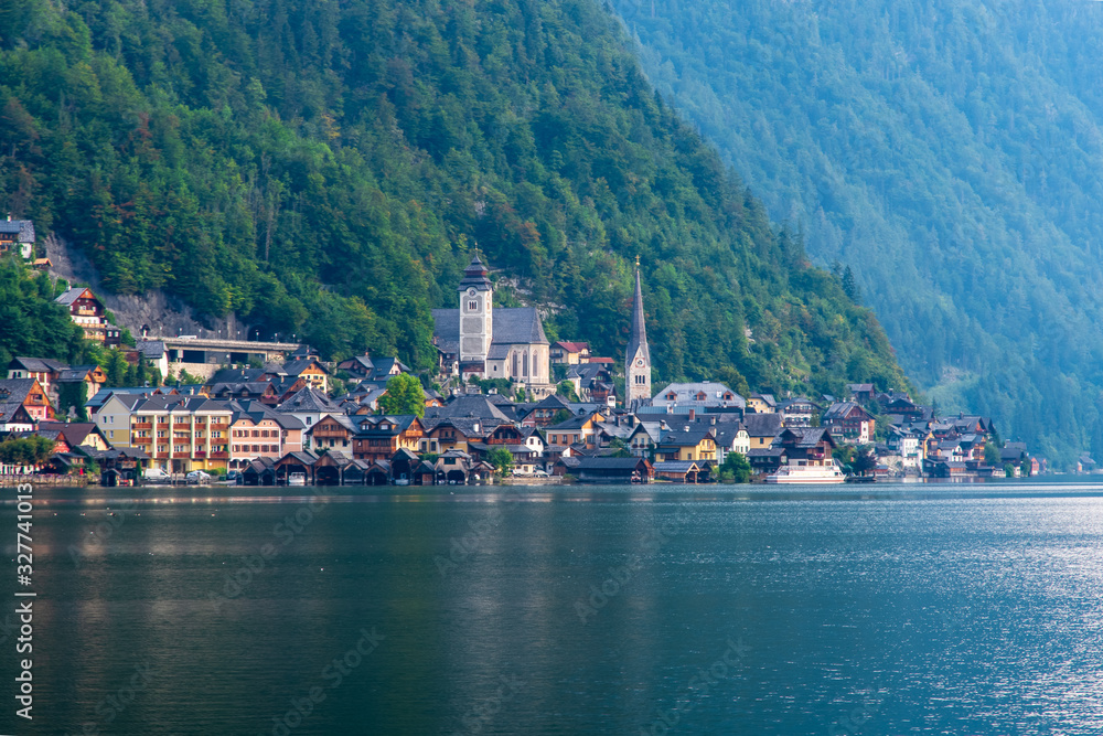 Scenic view of a medieval mountain town on the shores of an Alpine lake in the gentle rays of the morning sun. Hallstatt, Austria.