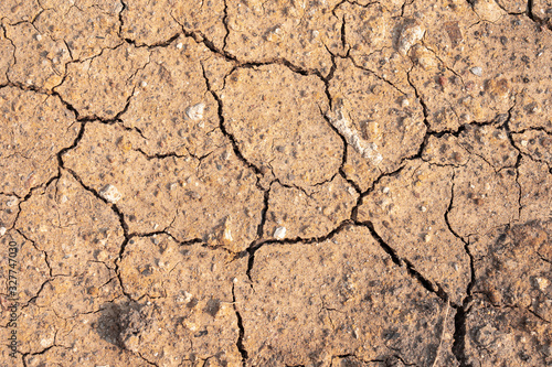 Surface of dry drought soil and ground cracked top view background.