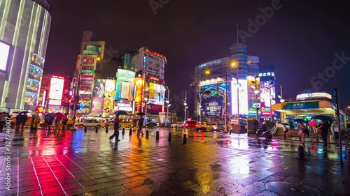 Time-lapse of traffic and people walking on crosswalk in the night at Ximending in Taipei, Taiwan. Ximending is the famous fashion, night Market and street food in Taipei. photo