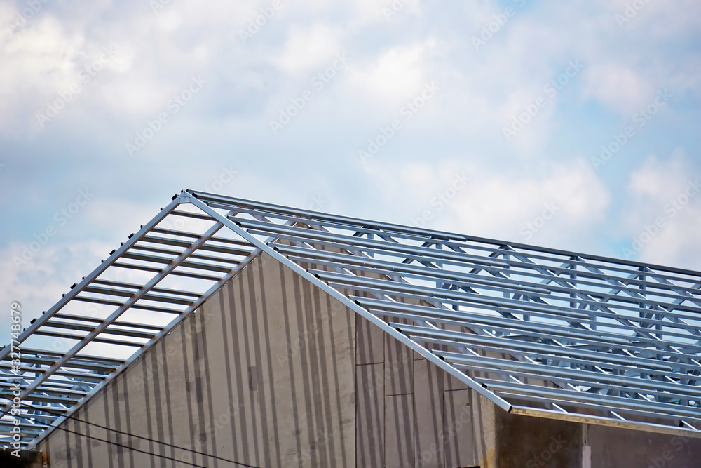 Steel frame structure of the house roof at building construction site, on sky background. Steel frame structure of the house roof at building construction site, on sky background.