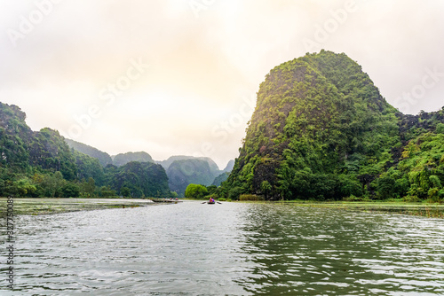 Tam Coc National Park - Tourists traveling in boats along the Ngo Dong River at Ninh Binh Province  Trang An landscape complex  Vietnam - Landscape formed by karst towers and rice fields