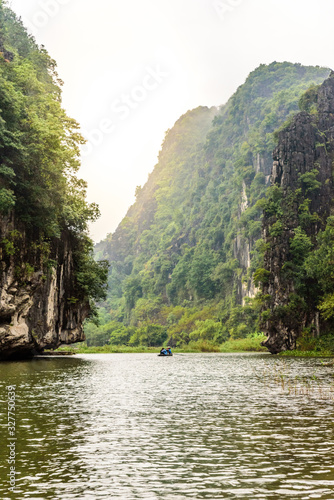 Tam Coc National Park - Tourists traveling in boats along the Ngo Dong River at Ninh Binh Province, Trang An landscape complex, Vietnam - Landscape formed by karst towers and rice fields