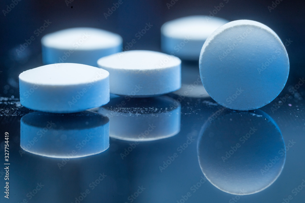Pills isolated on a dark background with reflections. Close up photo. Macro. Shallow depth of field. Medicine, health care concept. Pills isolated on a dark background with reflections. Close up photo. Macro. Shallow depth of field. Medicine, health care concept.