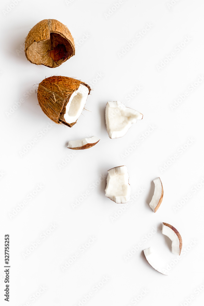 Cut coconuts - halfs and pieces - on white background top-down copy space Cut coconuts - halfs and pieces - on white background top-down copy space