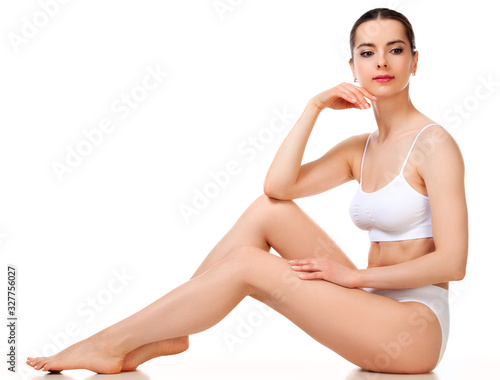 Wellness and beauty concept, beautiful slim woman in white underwear sitting on white floor.