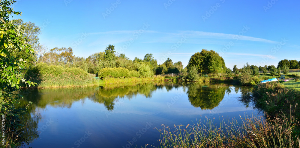 Panorama with a mirror reflection of the forest in the river