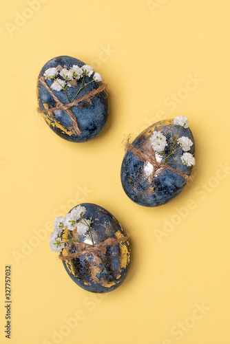 Flat Lay of Golden Easter Eggs in row placed on yellow background. Easter background or easter concept.