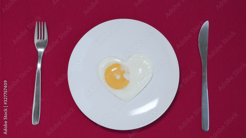 Plain white plate with heart formed egg. Valentine's concept Top view Plain white plate with heart formed egg. Valentine's concept Top view