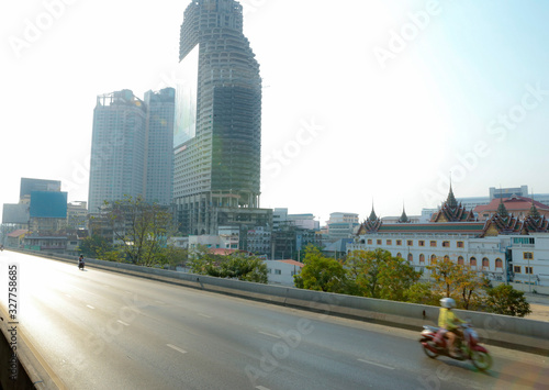Fototapeta Naklejka Na Ścianę i Meble -  Bangkok, THAILAND - February 24, 2020: In the morning many car and motorcycle is running from Saphan Taksin Station and cross the bridge in bangkok.