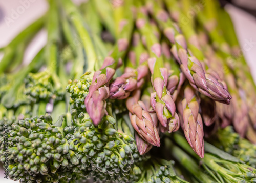 Close up and selective focus on organic asparagus tips and green broccoli heads
