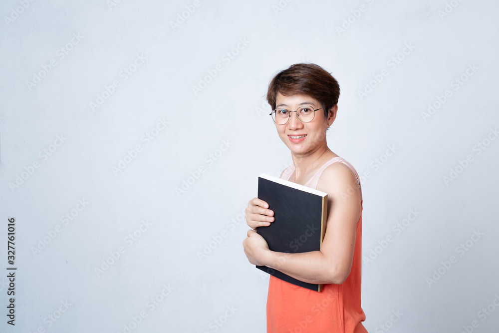 Portrait of an Asian short haired woman holding a book on a white background Portrait of an Asian short haired woman holding a book on a white background