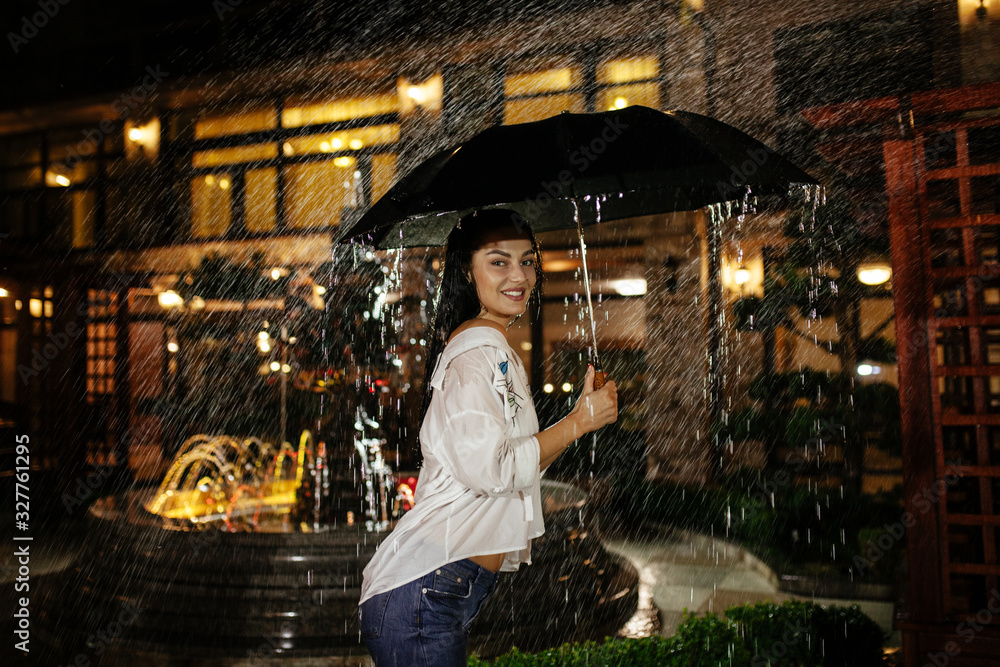 Girl in the rain under umbrella. Protection from rain.