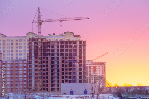 winter morning, the construction of multi-story frame houses with tower cranes