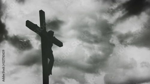 Jesus Christ crucified at Golgotha hill outside ancient Jerusalem. The Crucifixion of Christ with Stormy clouds time lapse. Vintage film look