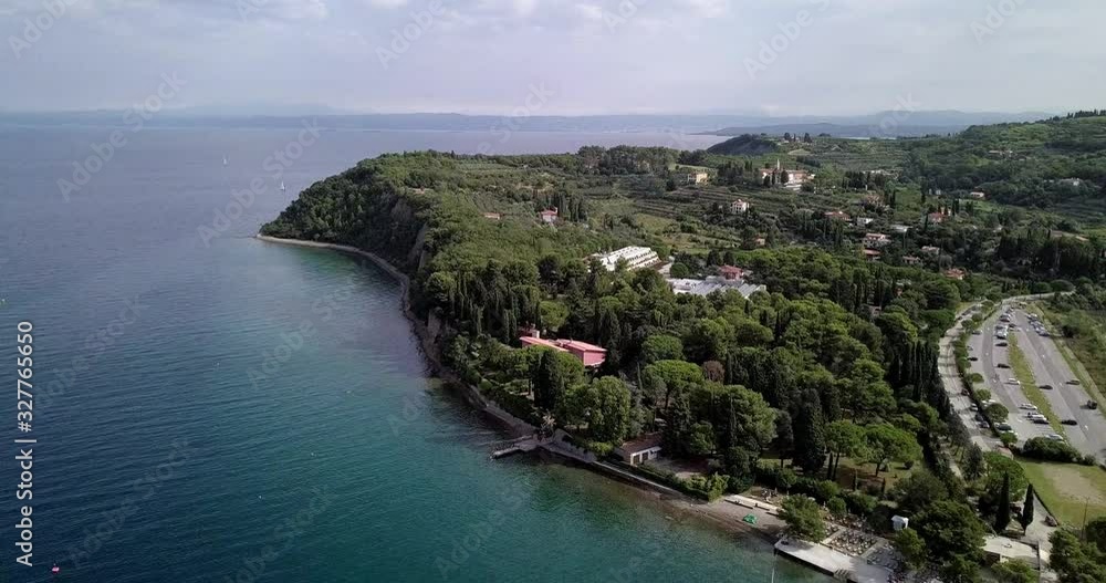 Green Trees And Modern Infrastructures Fringed On The Beautiful Island In Strunjan, Slovenia Surrounded By The Dark Blue Mediterranean Sea - Aerial Shot Green Trees And Modern Infrastructures Fringed On The Beautiful Island In Strunjan, Slovenia Surrounded By The Dark Blue Mediterranean Sea - Aerial Shot