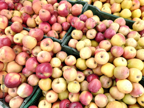 Sale of different varieties of apples in yellow, green, red in large quantities in the store. Fruit background.