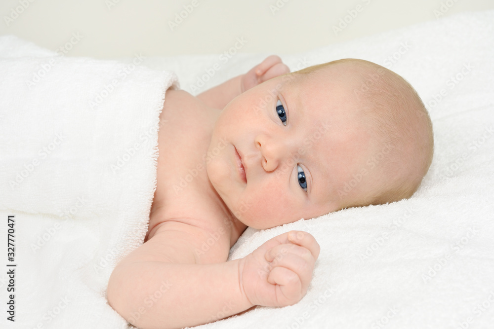 Baby boy lying on a white blanket Baby boy lying on a white blanket