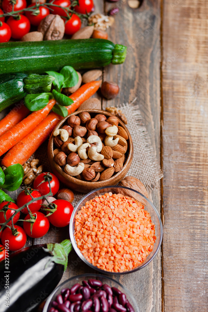 Concept of healthy vegan food, clean eating. Fresh raw ingredients, wooden background: vegetables, nuts, beans, lentils. Ripe seasonal product for clean meal. Flat lay, top view, copy space for text. Concept of healthy vegan food, clean eating. Fresh raw ingredients, wooden background: vegetables, nuts, beans, lentils. Ripe seasonal product for clean meal. Flat lay, top view, copy space for text.