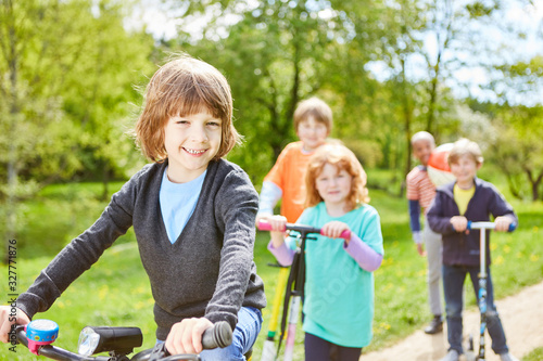 Kinder machen Ausflug mit Roller und Fahrrad