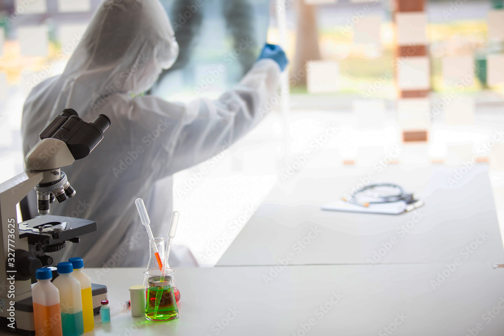 The doctor is testing a sample of biological tubes contaminated by Corona-virus Covid 19 and searching for a vaccine against the virus. In the laboratory and film samples of infected lung The doctor is testing a sample of biological tubes contaminated by Corona-virus Covid 19 and searching for a vaccine against the virus. In the laboratory and film samples of infected lung