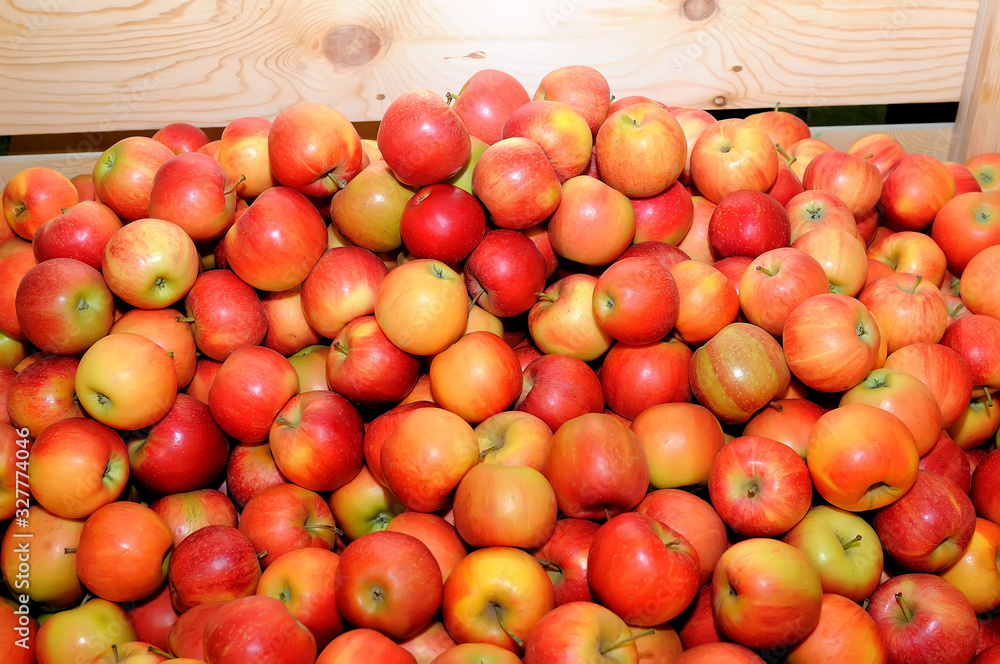 Red fresh apples in a pile on a wooden box Red fresh apples in a pile on a wooden box