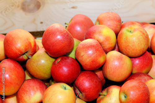 Red fresh apples in a pile on a wooden box