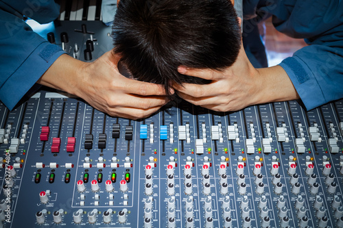 Billede på lærred asian male music producer, dj, sound engineer feel disappointed at bad sound in studio