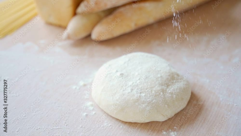 Close up view of baker hands kneading the dough on the table. Manufacturing process, working hard. Making bread, bread production. Workplace Close up view of baker hands kneading the dough on the table. Manufacturing process, working hard. Making bread, bread production. Workplace