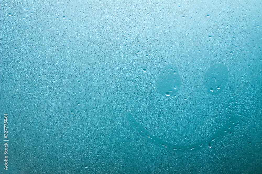 Obraz premium emoticon painted on glass window with drops background