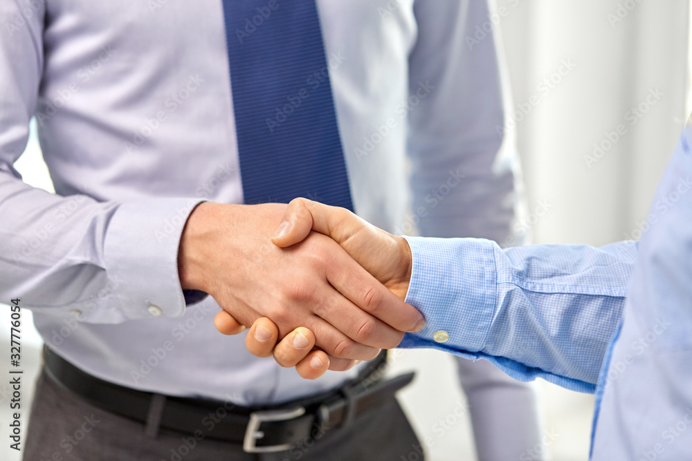 business people, cooperation, partnership and deal concept - close up of businessmen making handshake at office