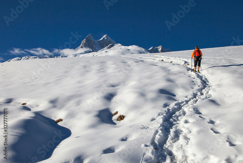 a girl with backpack is in the mountains in winter