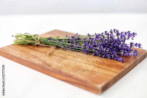 gardening, ethnoscience and organic concept - bunch of lavender flowers on wooden board photo