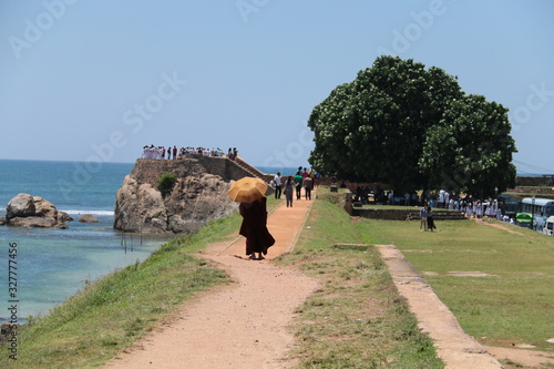 Monk holding an umbrella and walking in Sri Lanka