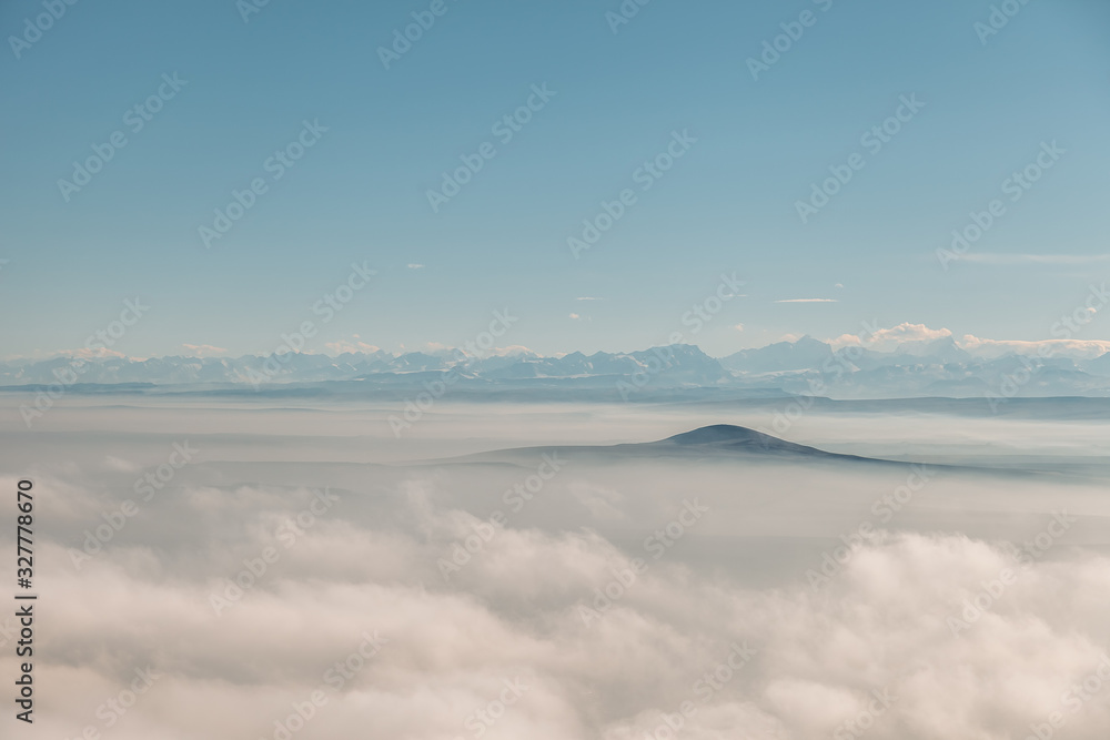 aerial view on a mountains covered clouds from the plane