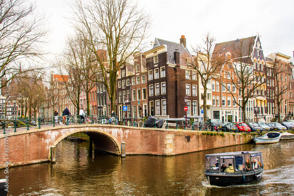 Amsterdam city center with traditional beautiful old houses, bridge, canal and boat