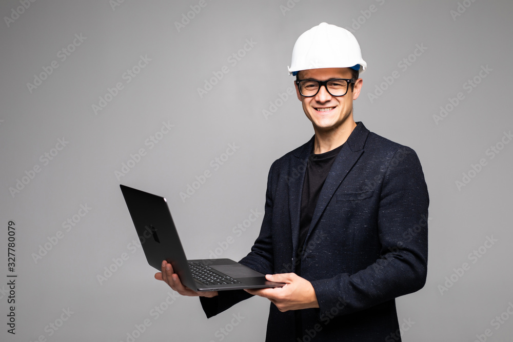 Smart young architect wearing glasses and yellow safety helmet which hands holding a laptop to check his planned work Smart young architect wearing glasses and yellow safety helmet which hands holding a laptop to check his planned work