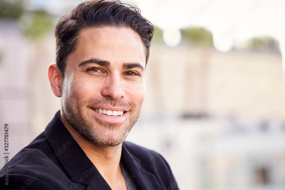 Portrait Of Smiling Businessman Standing Outside Office Building With City Skyline In Background Portrait Of Smiling Businessman Standing Outside Office Building With City Skyline In Background