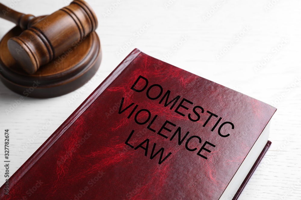 Domestic violence law and gavel on white wooden table, closeup Domestic violence law and gavel on white wooden table, closeup