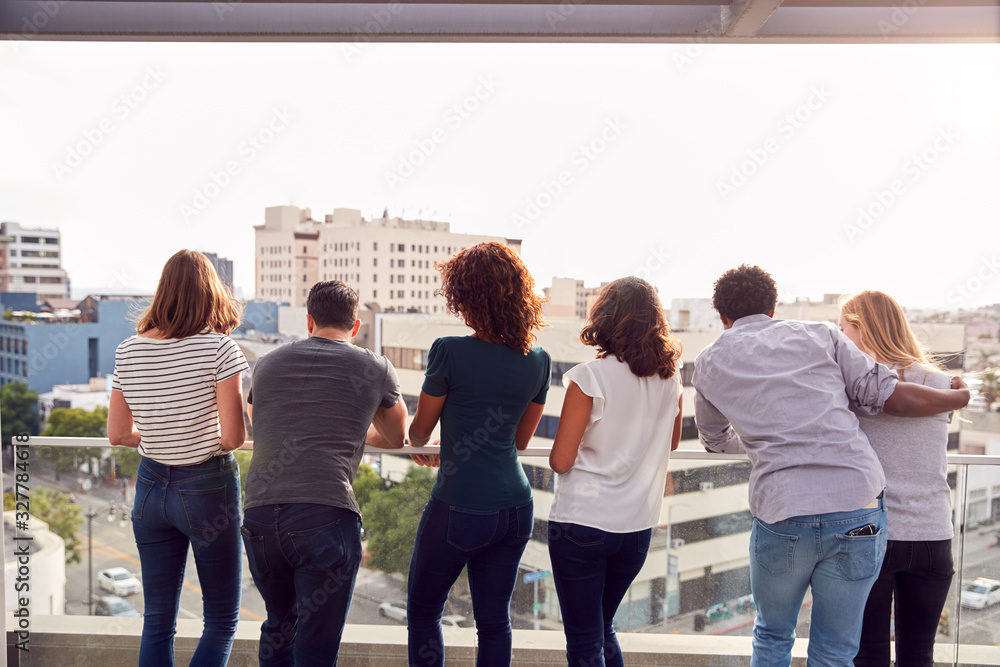Rear View Of Business Team Standing On Outdoor Balcony Overlooking City Skyline Rear View Of Business Team Standing On Outdoor Balcony Overlooking City Skyline