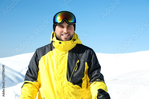 Happy young man in mountains. Winter vacation