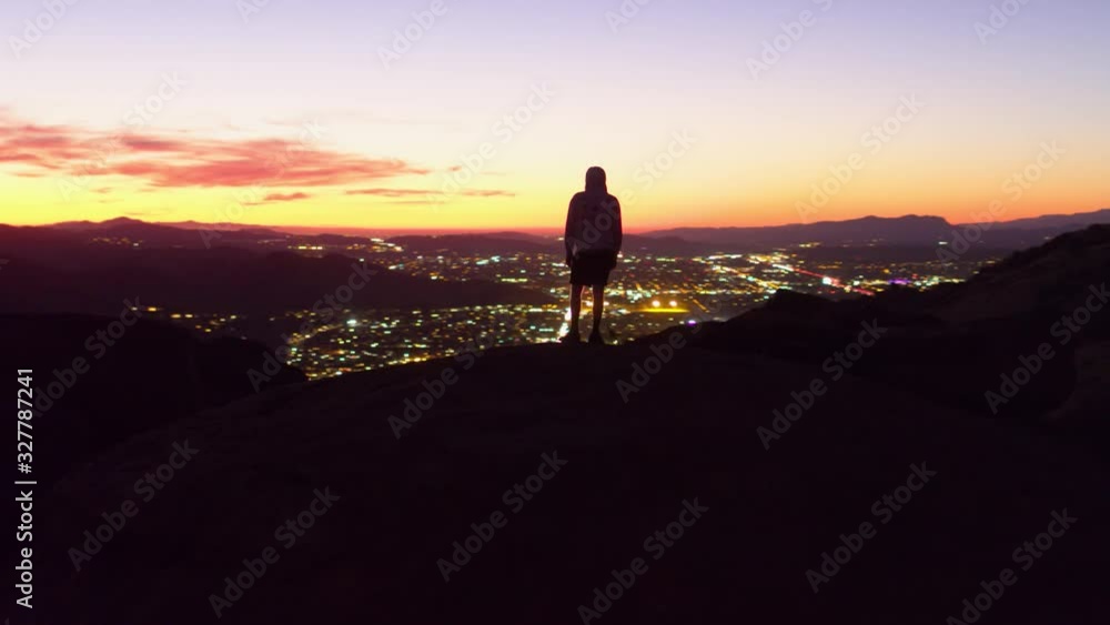 Aerial, tracking, drone shot around a man man on a hill, Santa Clarita city,scape in the background, during sunset, in Los Angeles, California, USA Aerial, tracking, drone shot around a man man on a hill, Santa Clarita city,scape in the background, during sunset, in Los Angeles, California, USA