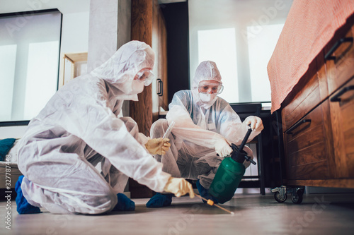 Foto Specialists in protective suits do disinfection or pest control in the apartment