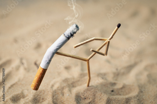 Fotografie stop smoking; anthropomorphic match kicking cigarette