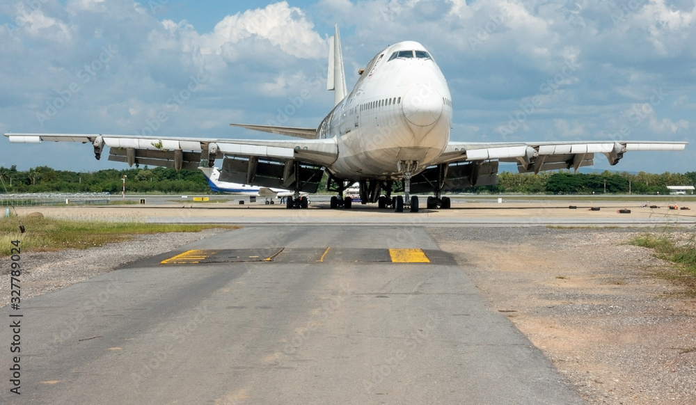 A large white commercial plane is parked in the airport. A large white commercial plane is parked in the airport.