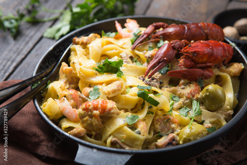 Photos Seafood fettuccine pasta with crayfishes, octopus shrims, on stone pan