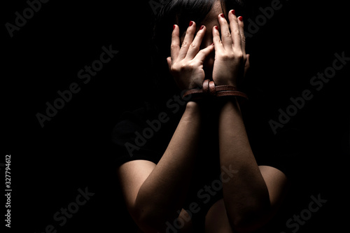 Obraz na płótnie Woman tied up with leather belt in emotional stress and pain. Women's Day