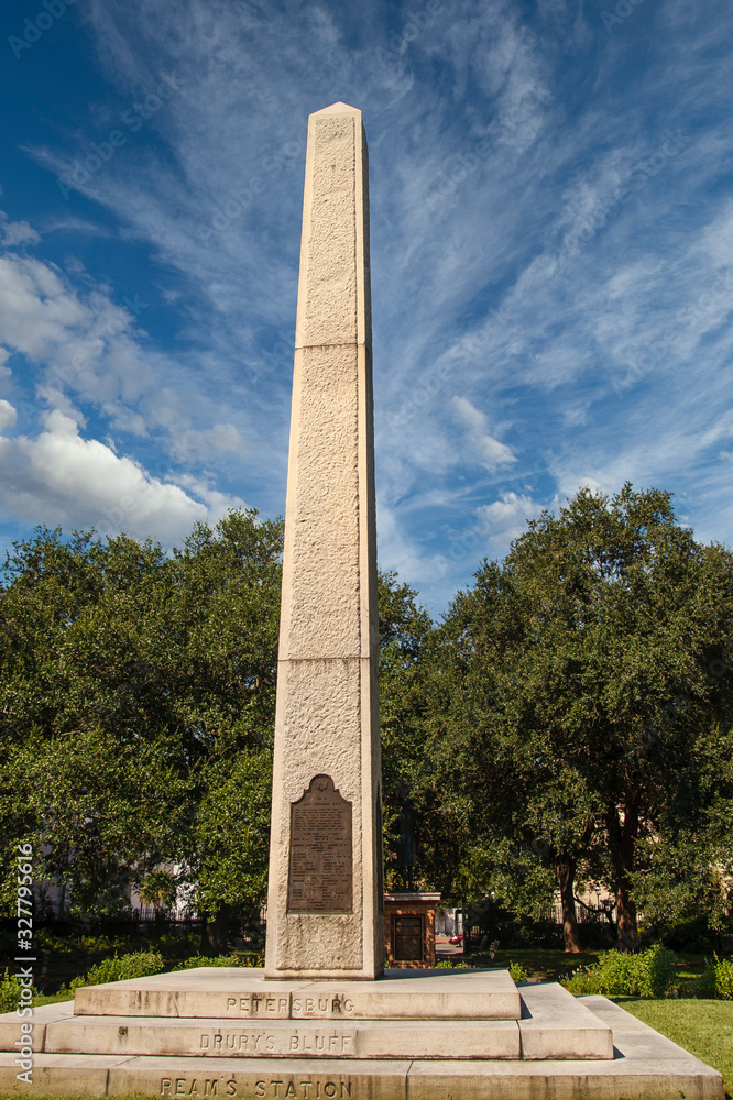 A granite civil war memorial under blue skies in park