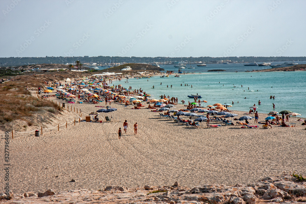 Bathers sunbathing in the wild and sunny Illetes beaches in Formentera on the Balearic islands of Spain.