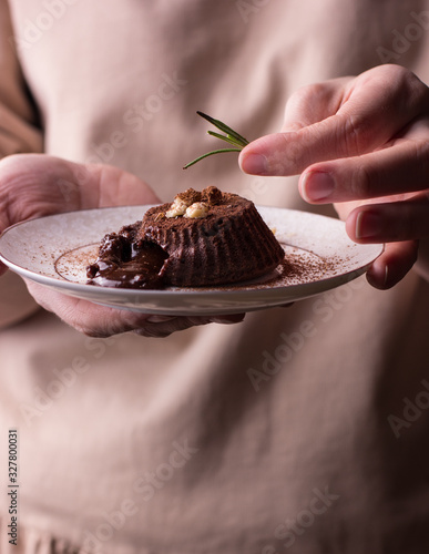 Chocolate fondan on a wthite plate in woman hands photo