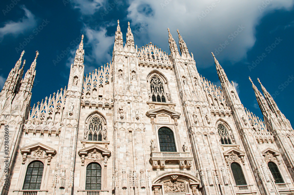 The facade of Milan duomo on a sunny day with the dark blue sky background, Milan, Italy.